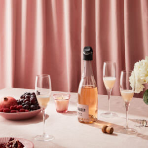 Sparkling Rosé scene with a pink monochrome set with a velvet curtain backdrop.