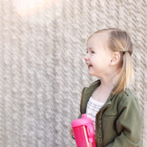 Young girl with pink sippy cup for children's brand, Boon.