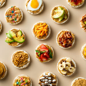 Studio photography of peanut butter rice cakes with various toppings.