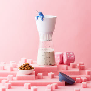 Conceptual arrangement of almond milk maker on pink foam pieces.