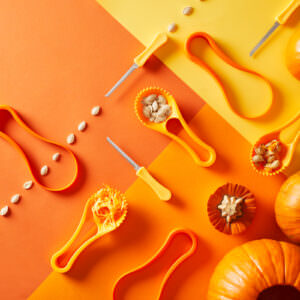 Lifestyle product scene with pumkins featuring a jack o'lantern tool kit on all orange background.