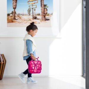 Toddler carrying lunchbox lifestyle photography.
